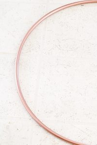 DIY your own spring hoop wreath from a $1 hula hoop! #springdecor #springwreath #DIYhoopwreath