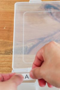 hand putting letter A on organizer