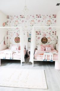 2 white canopy beds with name signs and pink bedding