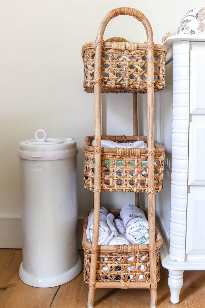 3 tier rattan storage next to white Ubi diaper pail and white changing table