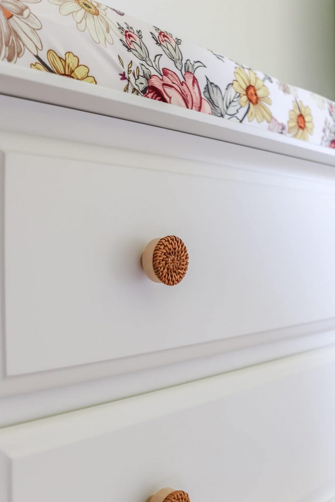 close up of rattan knobs on white nursery dresser