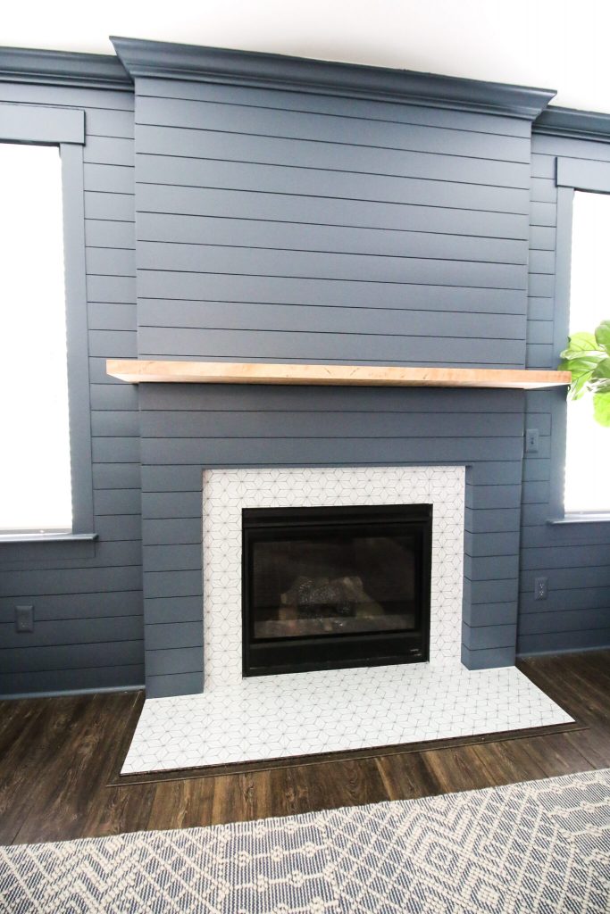 dark blue shiplap fireplace with white fireplace surround