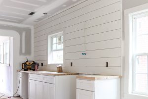 white shaker cabinets with butcher block counters and shiplap backsplash
