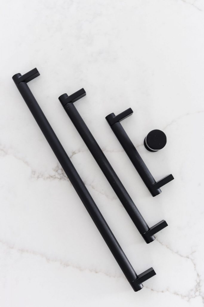 Emtek matte black knurled pulls and knob on white quartz counter