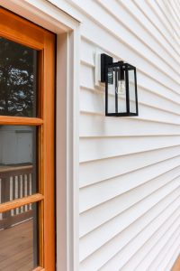 white vinyl siding with black outdoor sconce