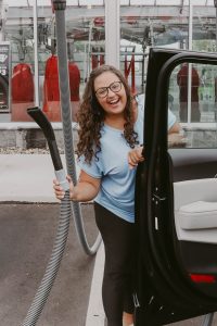 woman holding vacuum hose at Tommy's Express car wash