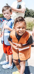 little boys in orange and blue vests