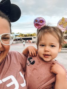 woman holding toddler girl with pigtails and encanto disney ears