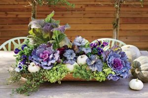 outdoor DIY fall decor table centerpiece with purple flowers and pumpkins