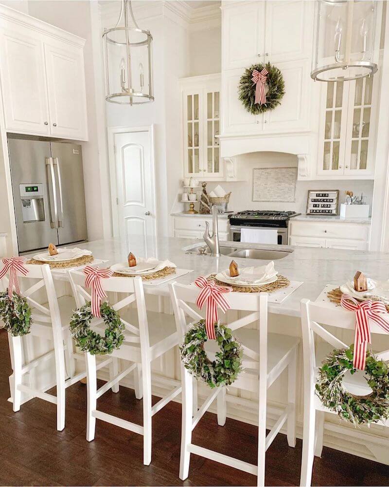 white bar stools in kitchen with wreaths and red and white ribbon