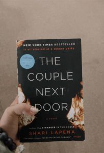 woman's hand holding the couple next door by shari lapenq