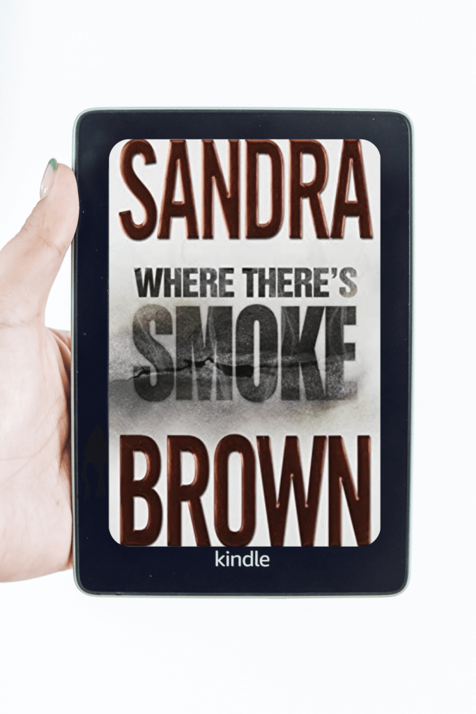 woman's hand holding kindle with sandra brown where there's smoke book cover