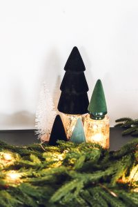 black and green flocked christmas trees on black entryway table