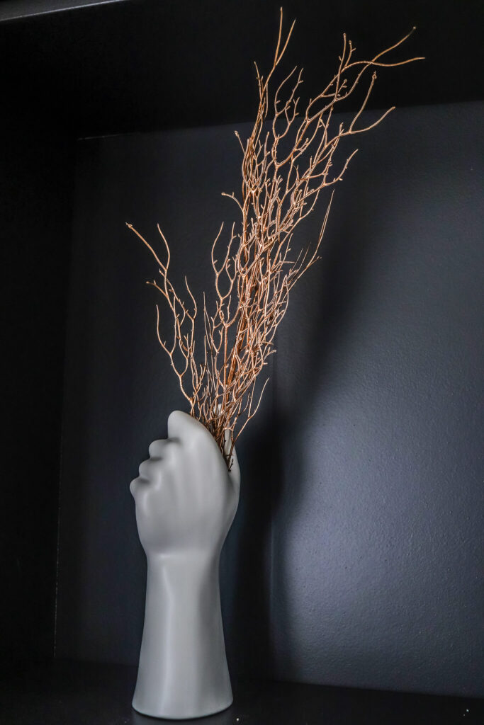 closeup of bookshelf decor in DIY black built in bookshelves around fireplace