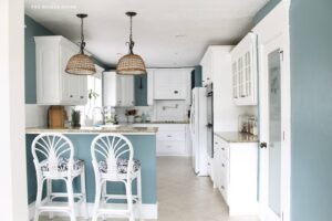 benjamin moore aegean teal painted lower kitchen cabinets with white upper cabinets and woven pendants