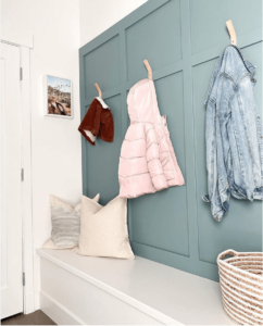 benjamin moore aegean teal painted entryway with white bench and jackets hanging on the wall