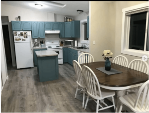 benjamin moore aegean teal painted kitchen cabinets with wood top table and white chairs