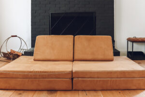 nugget couch sitting in front of a black fireplace