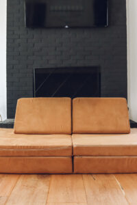 nugget couch sitting in front of a black fireplace