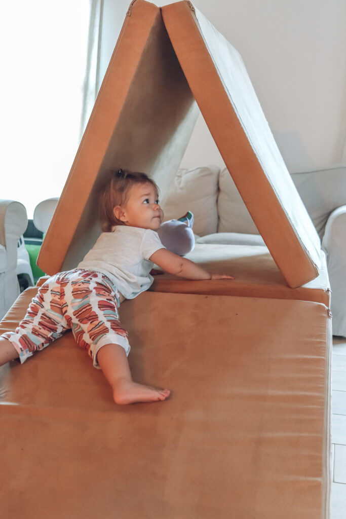 toddler girl on stomach laying on nugget couch