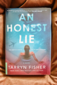 an honest lie by tarryn fisher laying on brown pillow