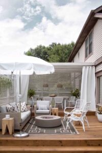 white patio umbrella and concrete fire pit on backyard deck