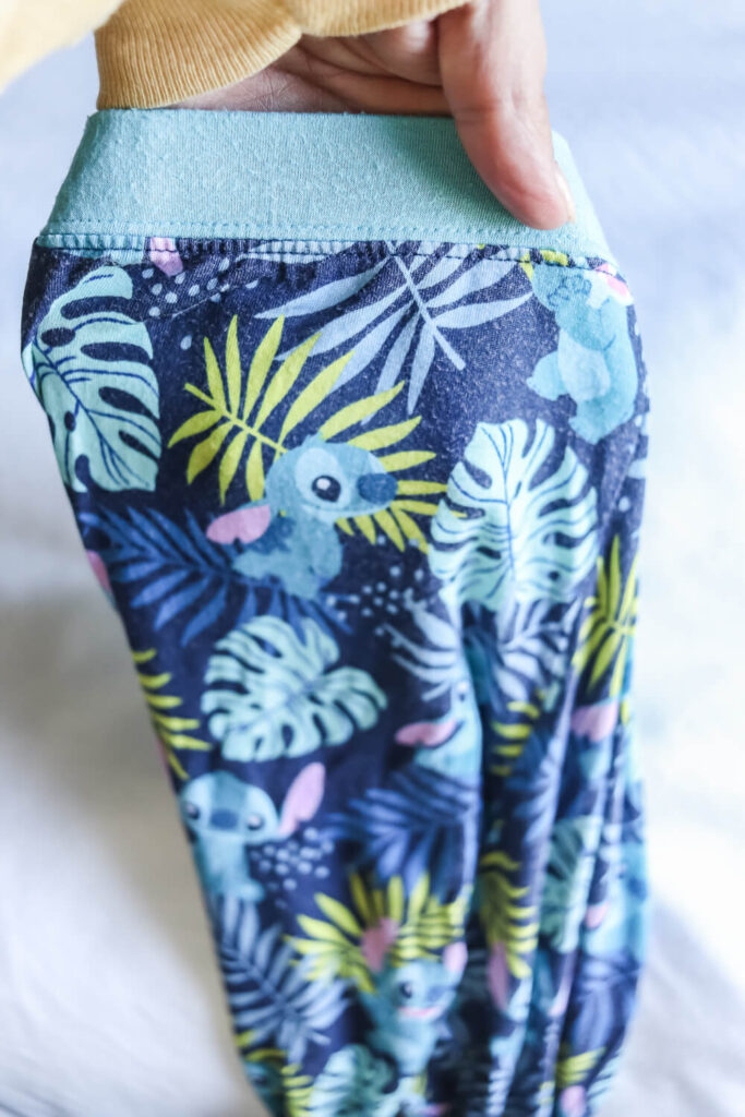 woman's hand holding kids bamboo pajamas with lilo and stich from Little Sleepies