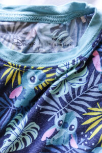 little sleepies bamboo lilo and stitch pajamas for kids laying on bed