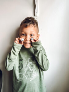 toddler boy holding up 2 dice