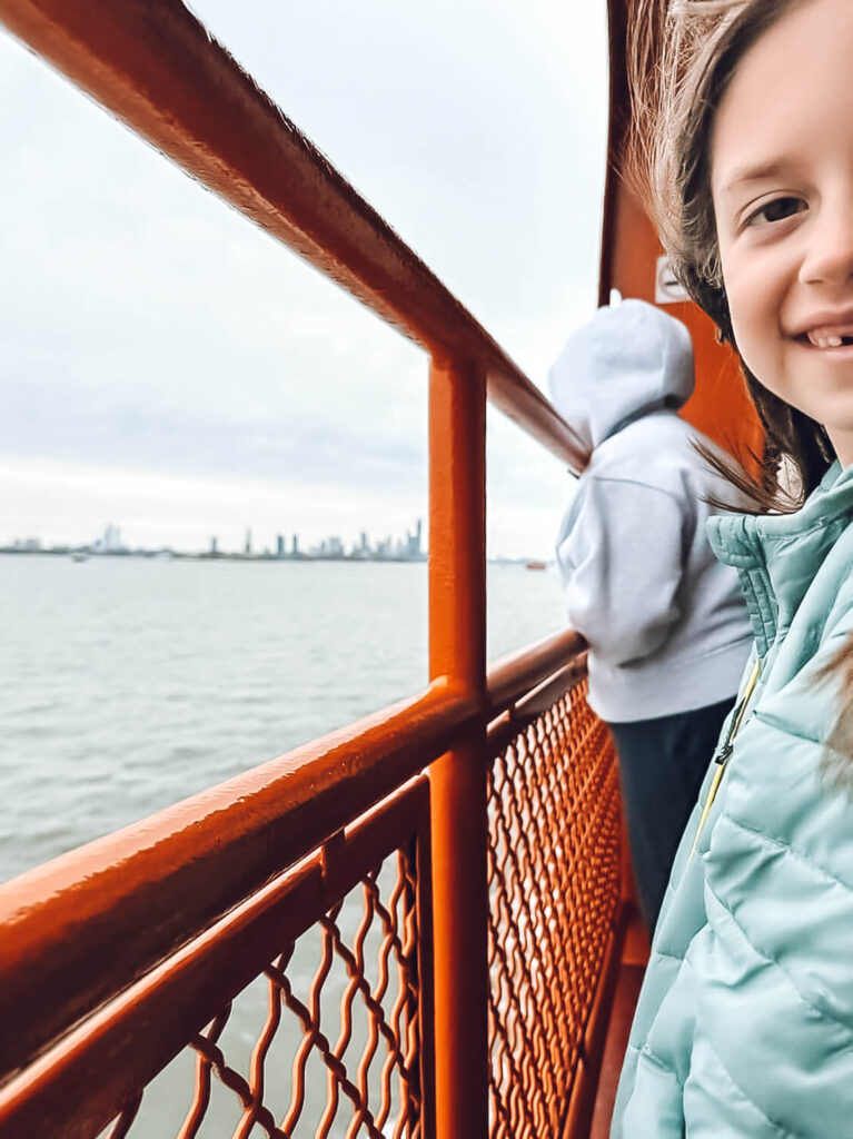 little girl on Staten Island Ferry visiting the Statue of Liberty