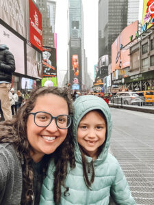 woman with brown hair and glasses with little girl in Times Square New York city