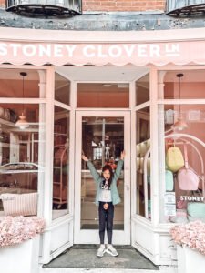 little girl in front of Stoney Clover Ln store front in New York City