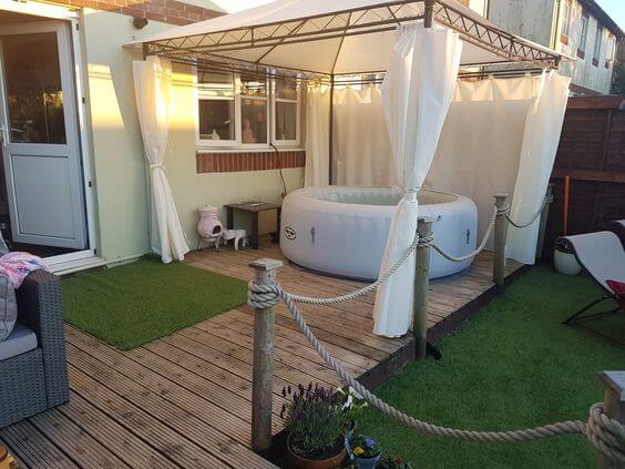 white inflatable hot tub with pergola and white curtains
