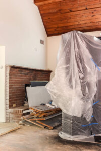 doors covered with painters plastic and brick fireplace