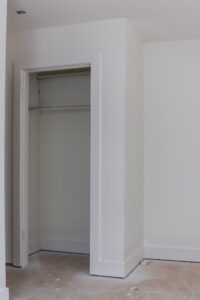 unfinished room with white walls and trim and window covered in painters plastic