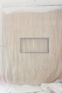 wood look tile in bathroom covered in painters plastic