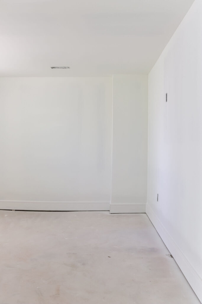 bedroom with white walls and unfinished flooring
