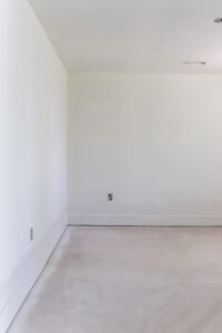bedroom with white walls and unfinished flooring