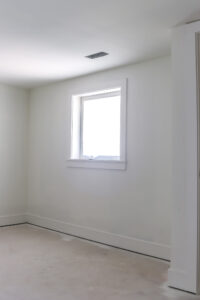 bedroom with white walls and unfinished flooring