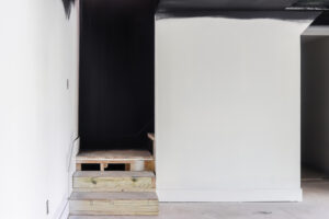 wood unfinished stairs with black shiplap accent wall