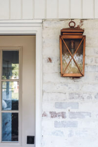 closeup of copper light on front porch of small ranch style home