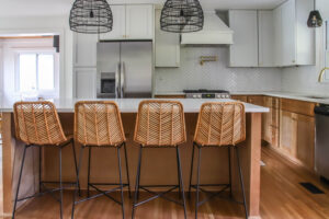 rattan bar stools and white upper kitchen cabinets with wood lower cabinets