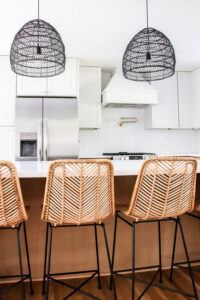 rattan bar stools and white upper kitchen cabinets with wood lower cabinets