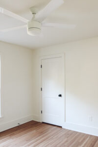 guest bedroom with white walls and white fan