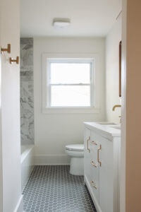 bathroom with white vanity and grey hex floors