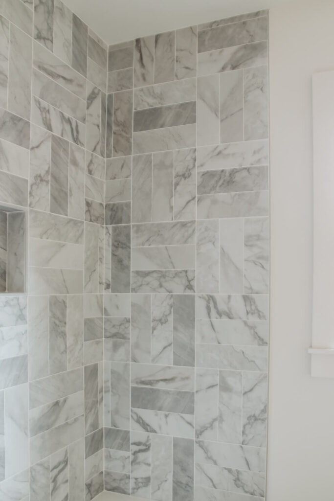 grey and white marble look subway tile in shower