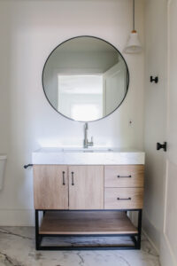 wood vanity with black hardware and white vanity top