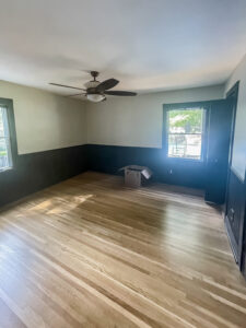 wall with wood floors and brown beadboard