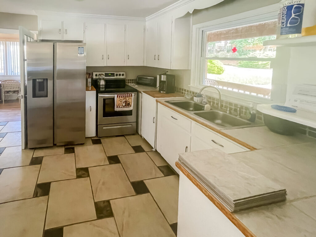 old kitchen with white cabinets and tile floor