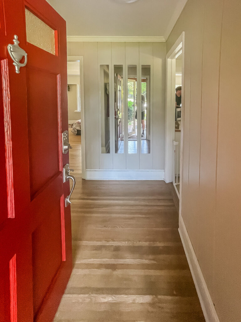 entryway with red door and mirrors straight ahead